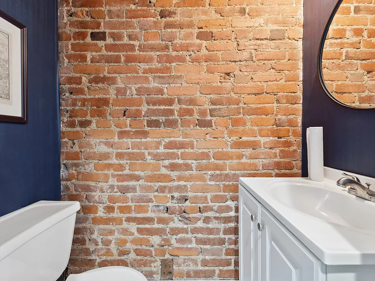 Exposed brick wall in Powder Room