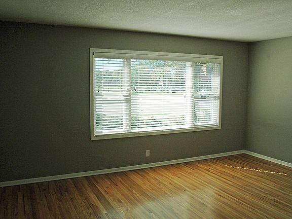 Large living area off kitchen with original wood floors