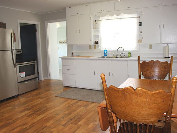 What a sweet kitchen featuring laminate flooring and brand new stainless refrigerator and range!