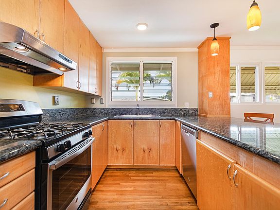 Kitchen has a gas range, dish washer, pendant lights, and lots of counter space.