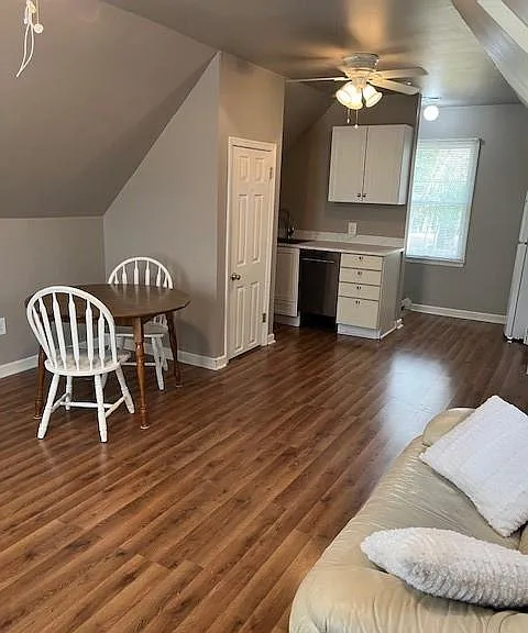 View of living space from opposite side-laminate flooring throughout and ceiling fans