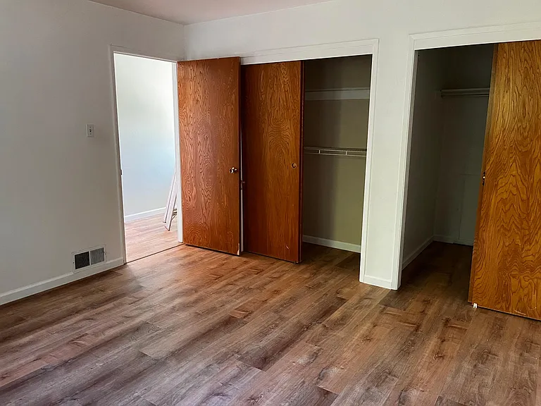 This second bedroom has two spacious walk-in closets and a new floor.