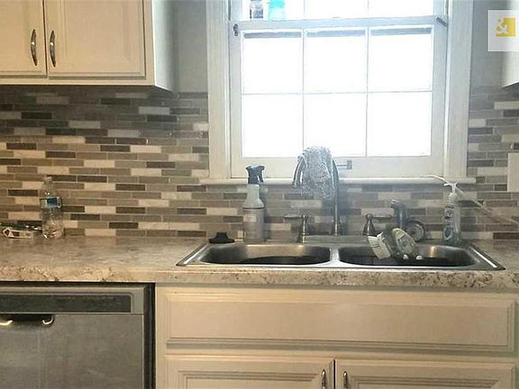 Beautiful backsplash tile and double deep sink with goose neck faucet.