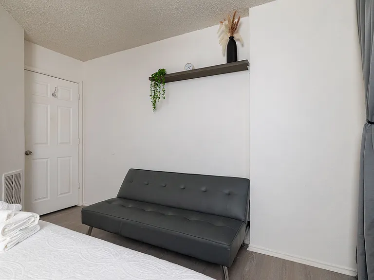 Bright bedroom with a stylish butterfly accent wall and queen-size bed.