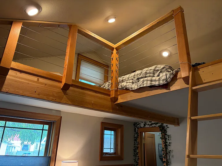 Main floor bedroom with sleeping loft and ladder.