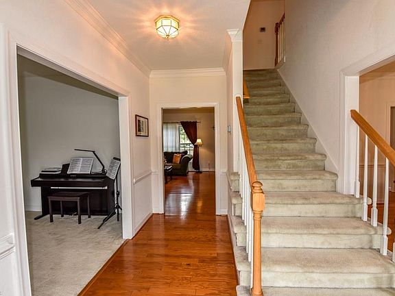 Front foyer with stairs, formal living room on the left and formal dining room on the right