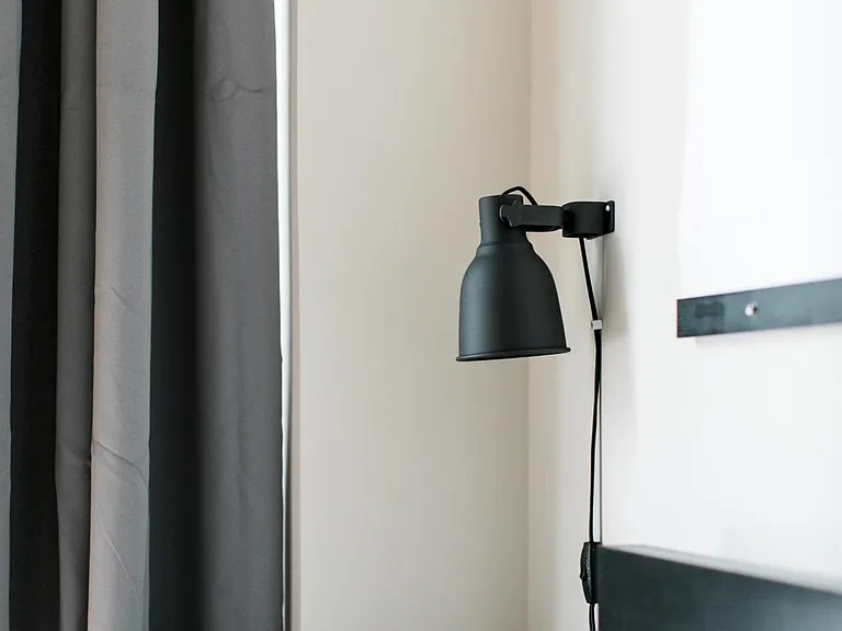 Bedroom includes designer furniture with under-bed storage, as well as custom designed feature closet door