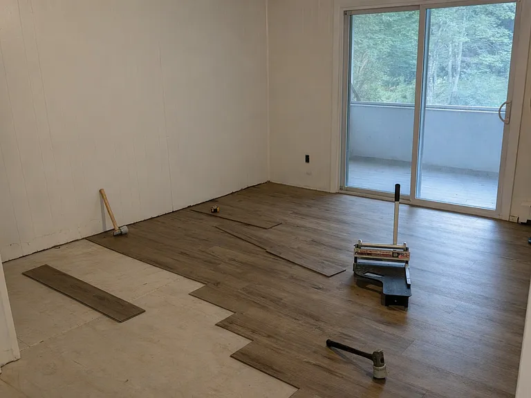 Living room with slider to screened porch. Note that a new floor is being installed.
