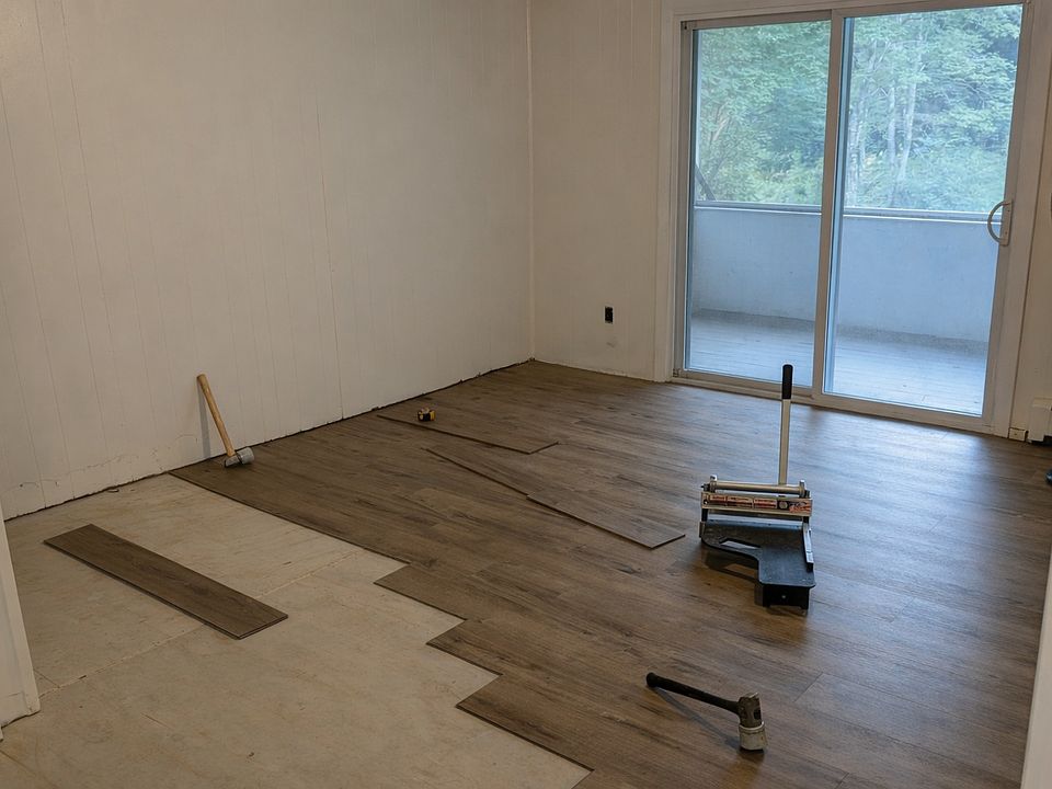 Living room with slider to screened porch. Note that a new floor is being installed.