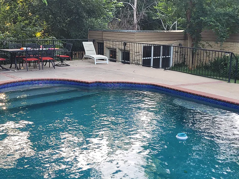 Another view across the pool to the bungalow/pool house. Can see dog run behind the pool.