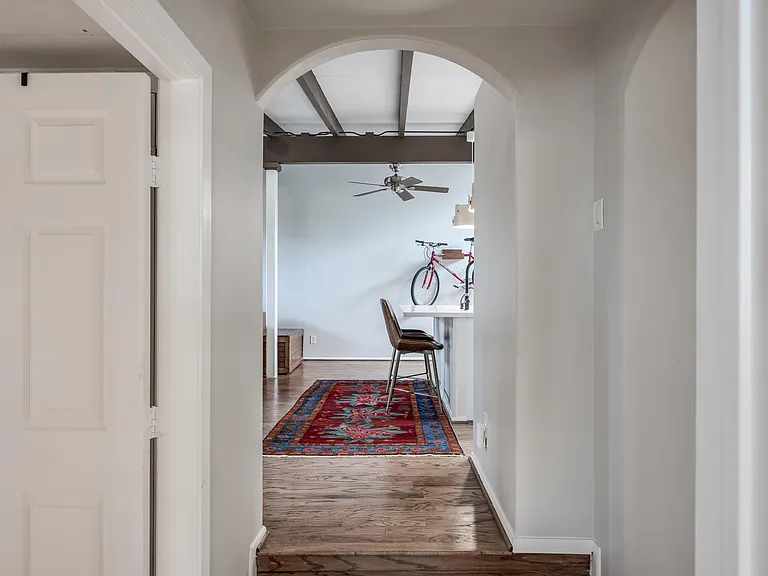 hallway in front of bedrooms looking into kitchen