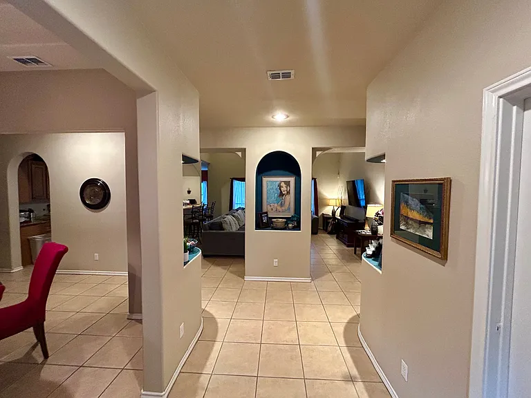 Custom built in areas with downlighting highlight decor leading in to open concept dining, living and kitchen area