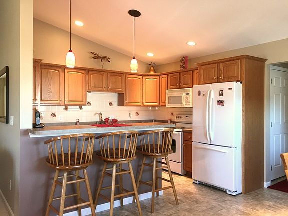 The kitchen is nice and it has a raised bar and pendant lighting.