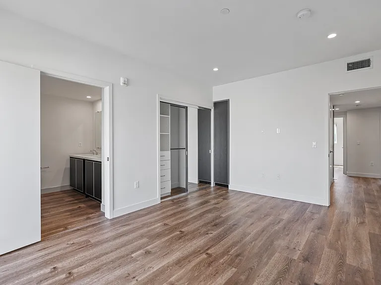 Spacious Bedroom with Closet with Organizers, Recessed Lighting, Vinyl Flooring, and Bathroom