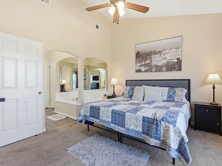 Master bedroom with king size bed and 2 person hot tub, ceiling fan