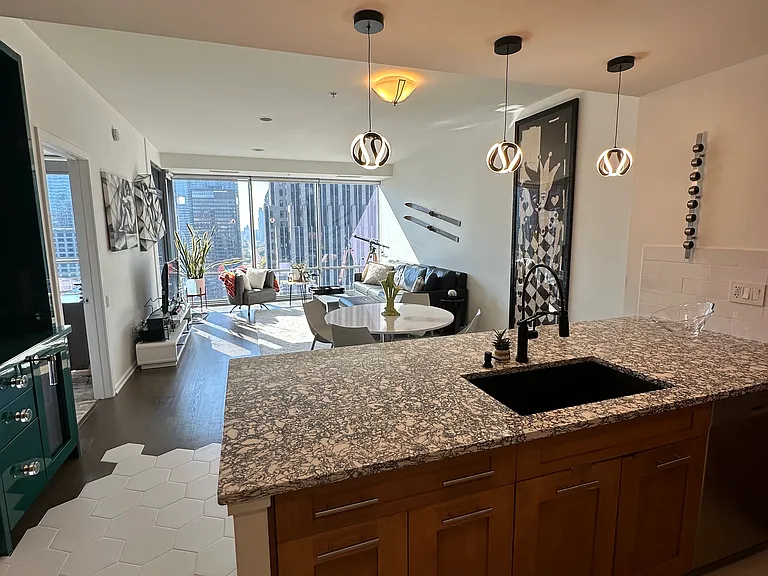 Open concept kitchen, custom bar with wine fridge, dining and living room