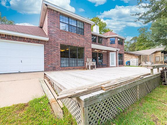 Deck extends length of home, drive through garage.
