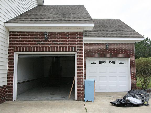 Two car garage has workspace area and storage room