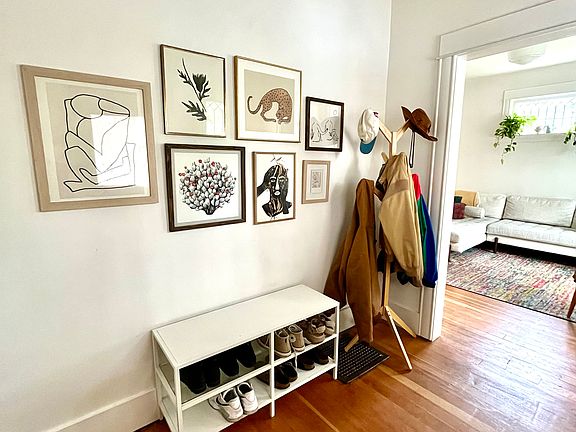 Entry and view to light-filled living room with new windows and one original stained glass window.