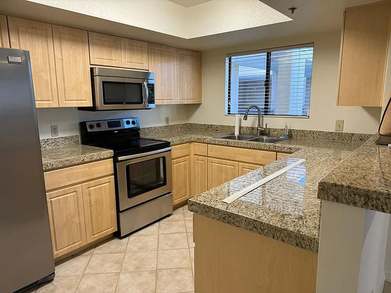 The kitchen is great for cooking and entertaining with lots of countertop space and cabinets. The ceiling light is bright.