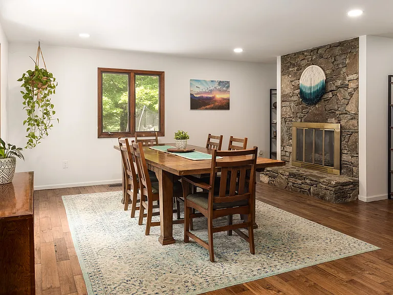 Spacious dining room w/ seating for 8 + gas fireplace. Bright and airy open layout connects with the kitchen & charming back porch.