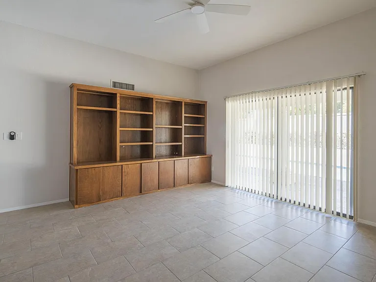 Den with built in bookshelves and sliding glass door to patio and pool