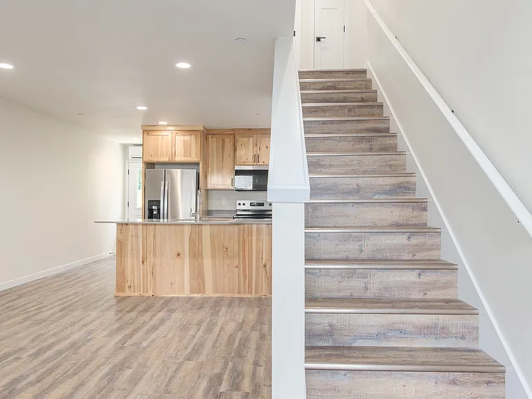 Living and Dining area with View of Kitchen and Stairs to Upper Level