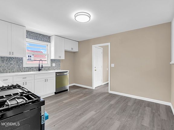 White cabinets, tile backsplash, and new stainless appliances