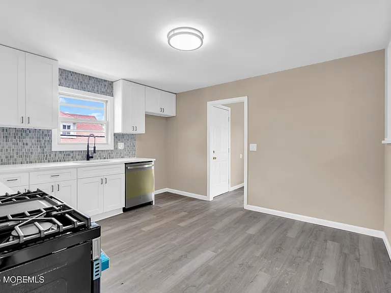 White cabinets, tile backsplash, and new stainless appliances