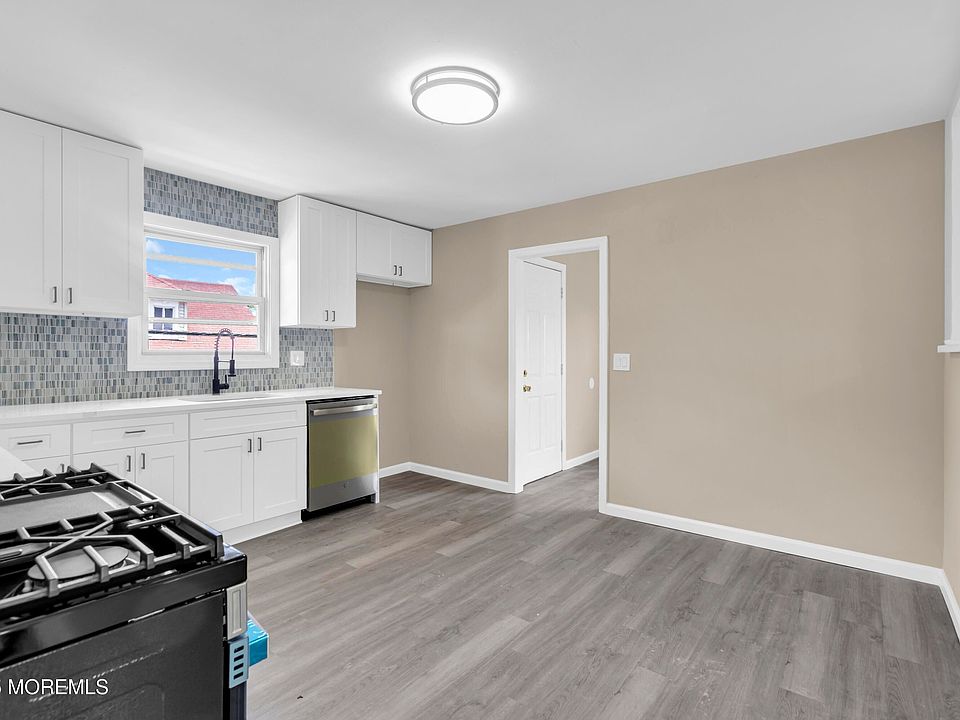 White cabinets, tile backsplash, and new stainless appliances