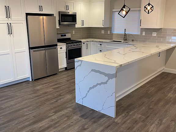 11' waterfall quartz peninsula provides dining space for up to 6 people, with undercounter outlets for convenience as a workstation