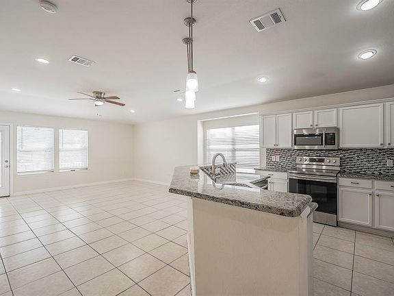 Kitchen featuring appliances with stainless steel finishes, white cabinets, pendant lighting, backsplash, and recessed lighting