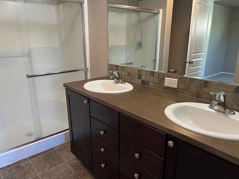 Double sinks shower in shared bath