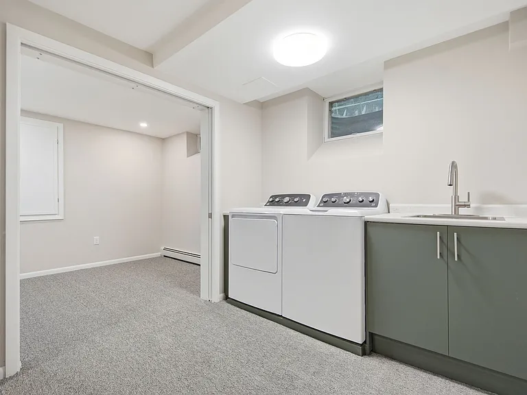 Large in-unit carpeted utility room with washer, dryer, utility sink and area for possible storage shelves and / or exercise equipment. Sliding French doors provide privacy for attached Office / Study