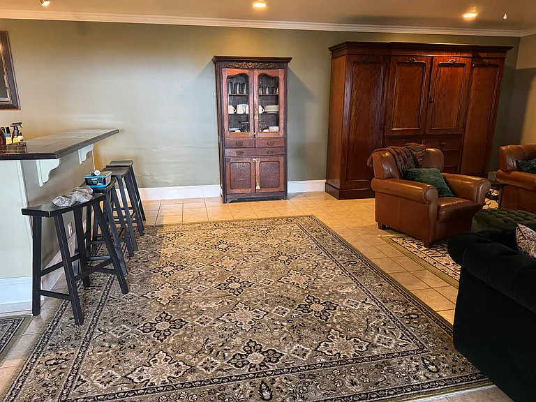 Center front interior from entrance. Left is the bar and dining area and far right is the Kaena en suite. To the right is the living area. The doorway with the light on is the guest bathroom. The Ewa suite opens from the other right door.