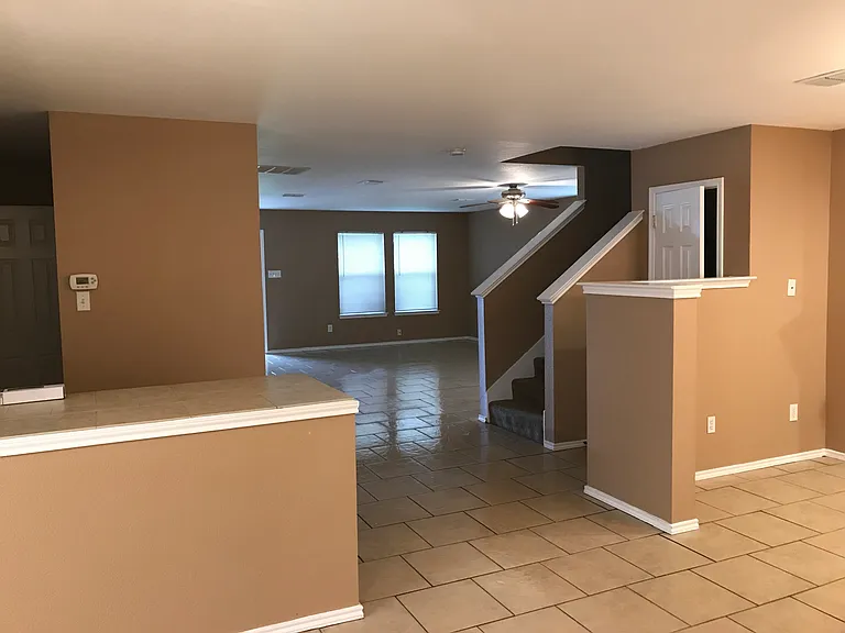 Kitchen to living room and stairs to second floor.