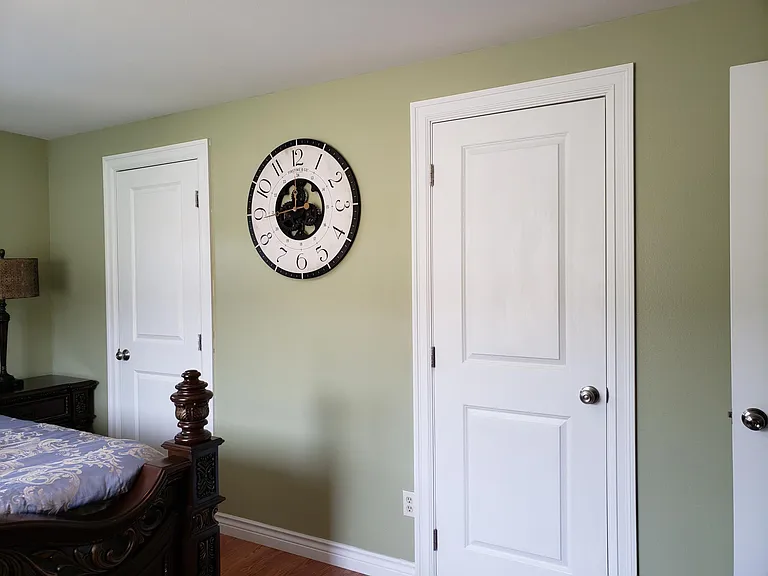 Same bedroom with door to closet and door to full bathroom with a tub and shower combo.