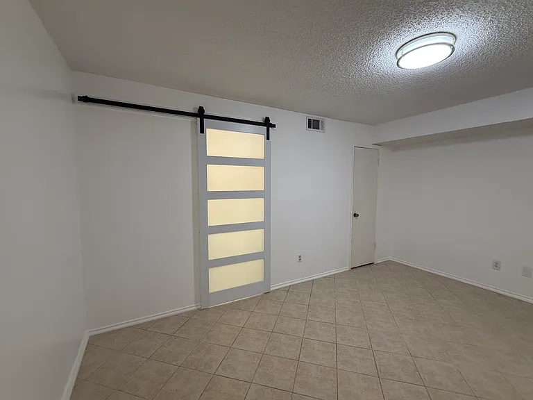 Bedroom with siding barn door to bathroom.