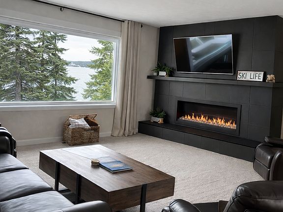 This image reflects a proposed designer update to the fireplace wall. The fireplace is currently brick; no other elements of the room have been modified. All other photos of the home and views, are unaltered.