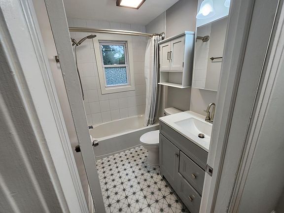 Newly remodeled bathroom with new toilet, medicine cabinet, vanity, shelving, detachable shower head, & floors.