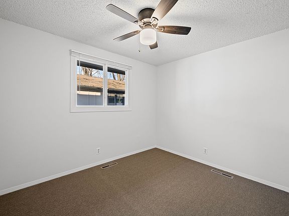 Bedroom one with new window coverings, carpet, and ceiling fan