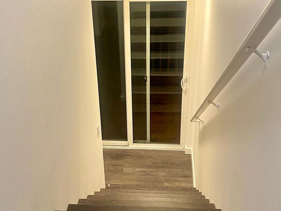 Stairs from upper floor with a sliding glass door to the new cedar deck.