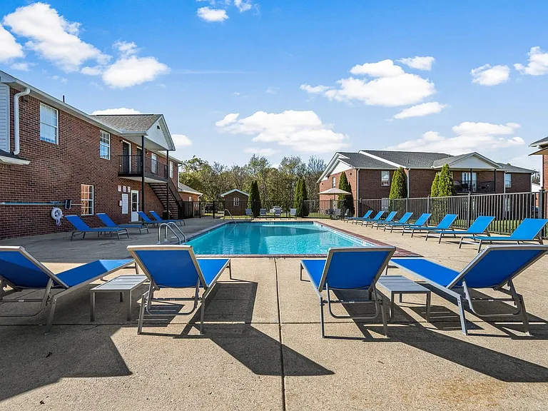 Expansive sundeck surrounding pool with lounge chairs at Saddlebrook Apts