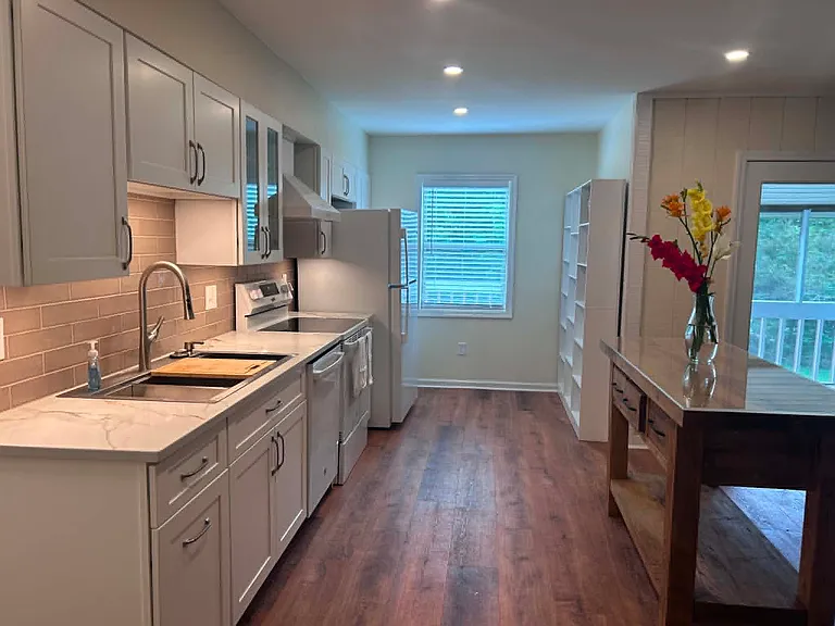 view of kitchen from great room 

(screened in porch to right of photo... railing of the back deck can be seen out kitchen window)