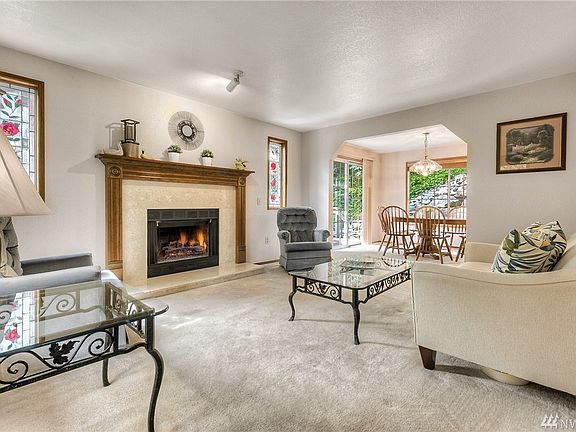 The gracious formal living area, made cozy by the wood burning fireplace, is located just off the entry.