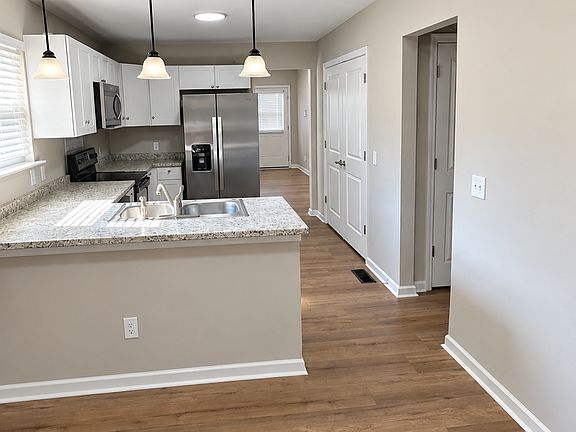 Open-concept living and dining area with modern flooring and pendant lighting.