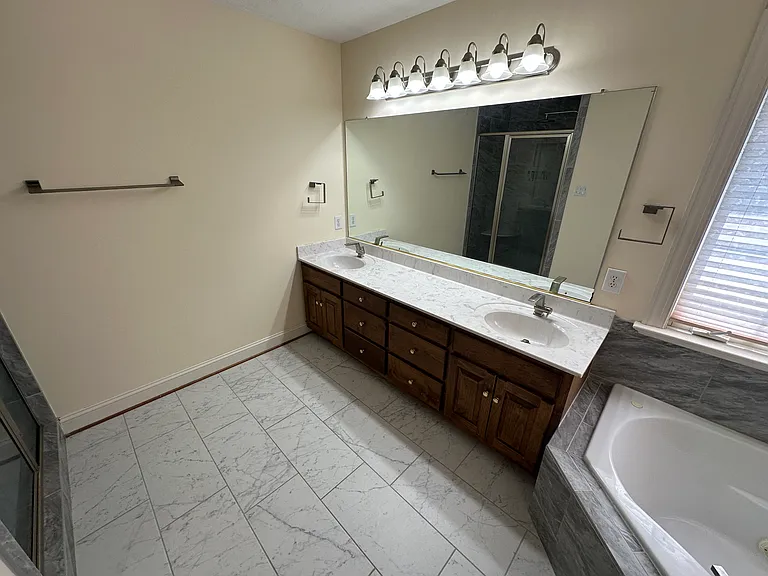 Primary bathroom with tile floor, double vanity and jetted tub