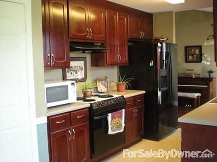 Elegant and Contemporary Kitchen : The cherry cabinets are accented by the tile floor and black appl