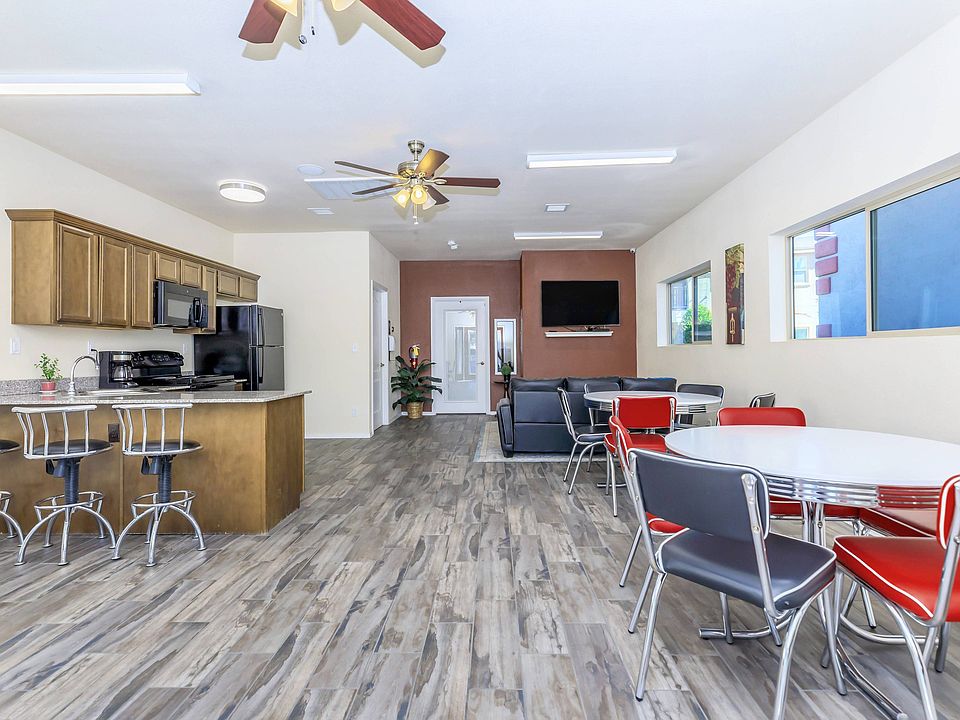 Bella Vista Place offers a spacious community area with a kitchen, lounge seating, and dining space.