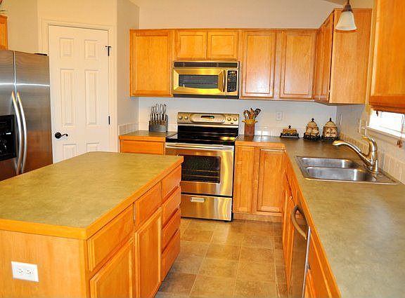 Large kitchen with new stainless appliances.